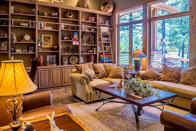 A living room with different patterns and colors and a bookcase full of items.