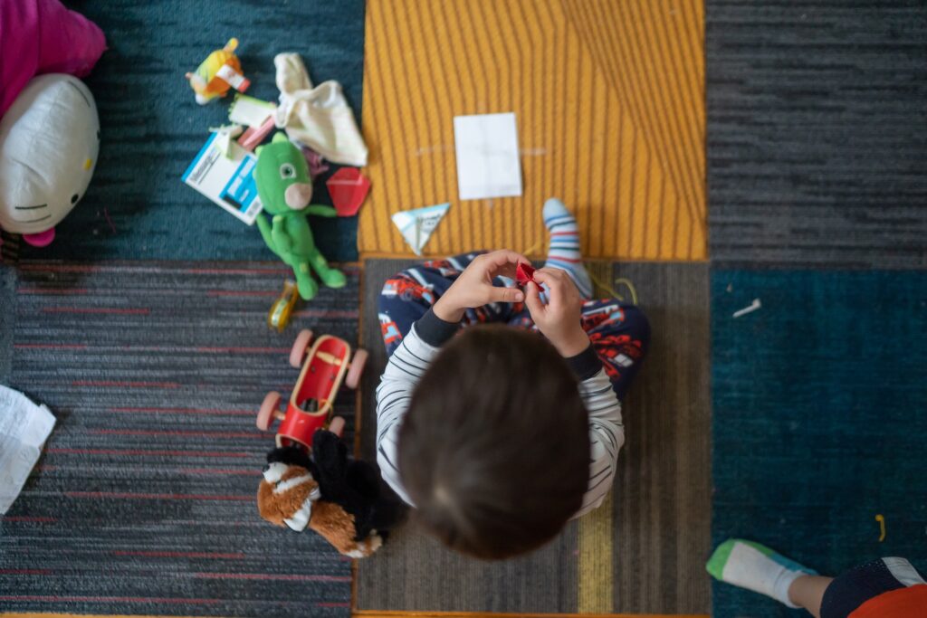 A kid playing with toys on the floor