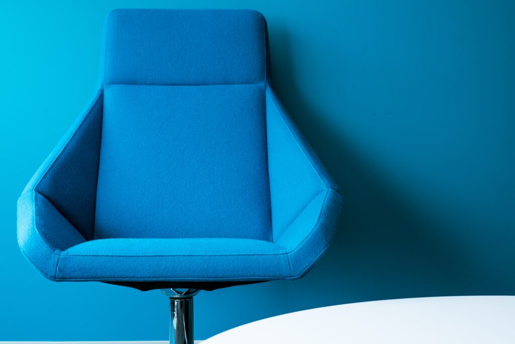 A blue office chair against a blue background