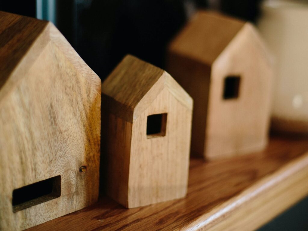 Three small wooden house sculptures that you can use as winter decor all year