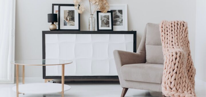 A corner of a living room with a chair, table, and minimalistic decor pieces.