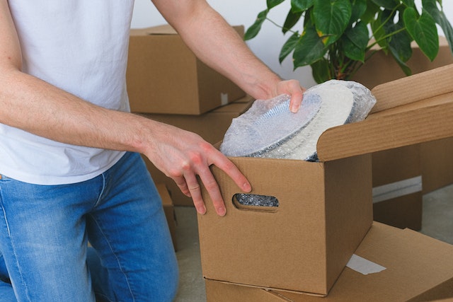 A person packing plates in a box