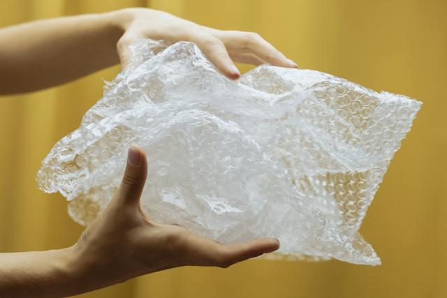 A person holding bubble wrap used to pack your home décor for the move