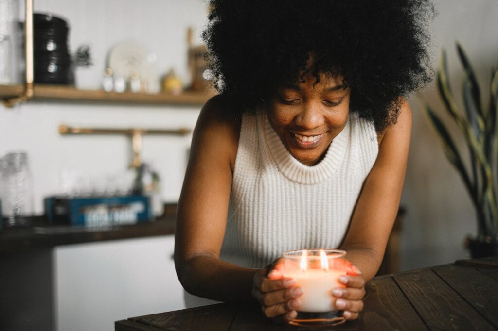 A happy woman with a burning candle at home