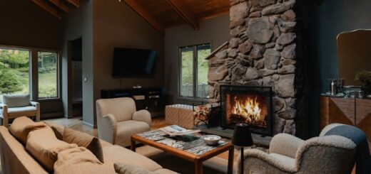 A cottage living room with a stone fireplace. Clutter